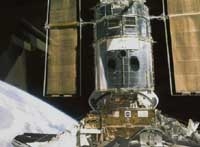 Arrimage de la navette américaine Discovery au télescope spatial Hubble. Crédits : NASA
